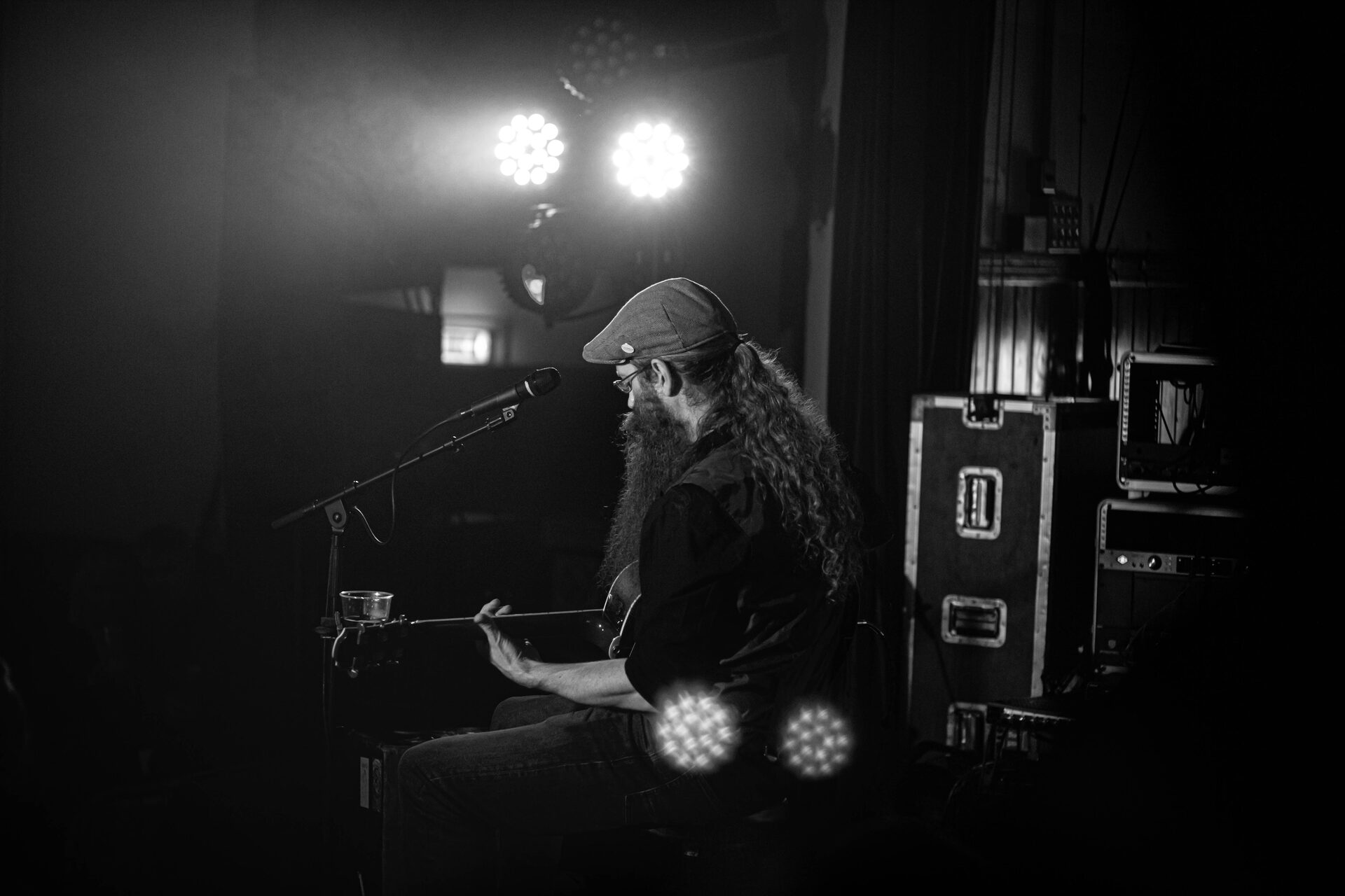 Black and white portrait of a guitarist under twin spotlights
