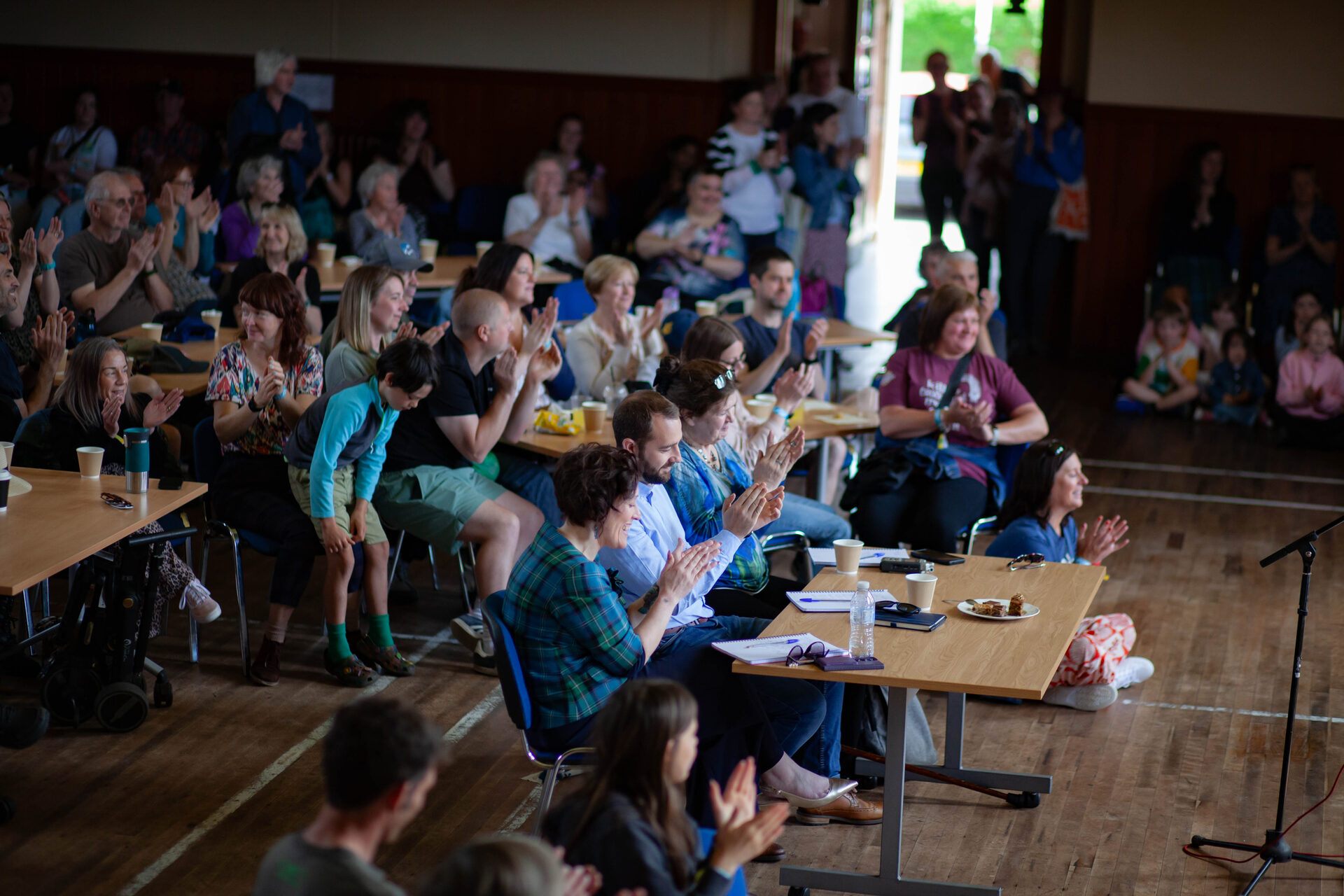 A full hall clapping at the Sunday community day
