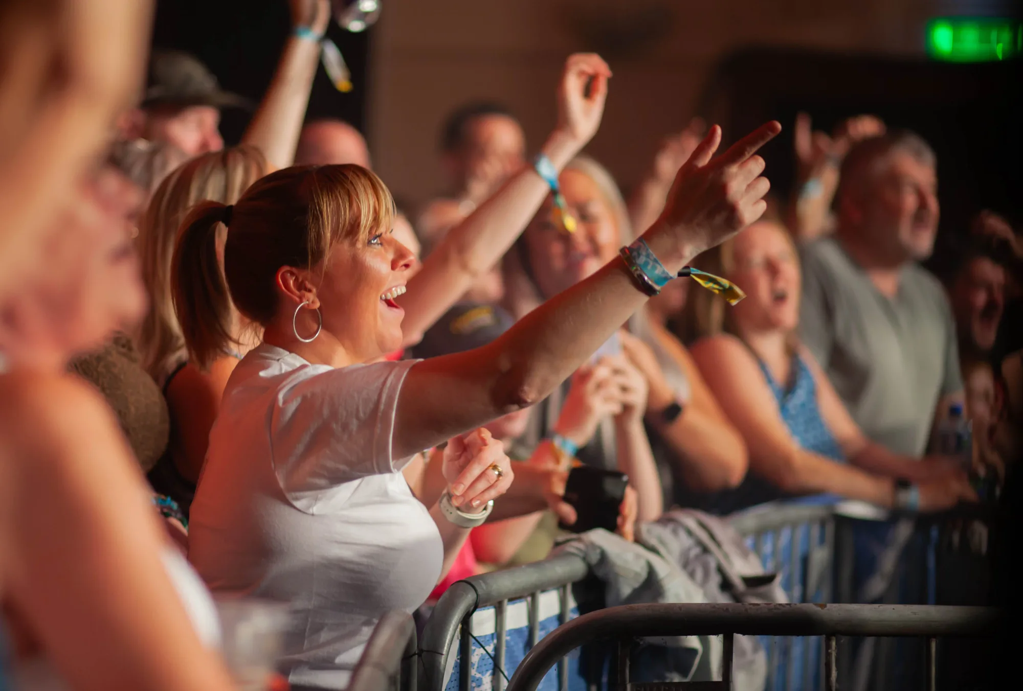 A fan at the front barrier singing along as the crowd cheers